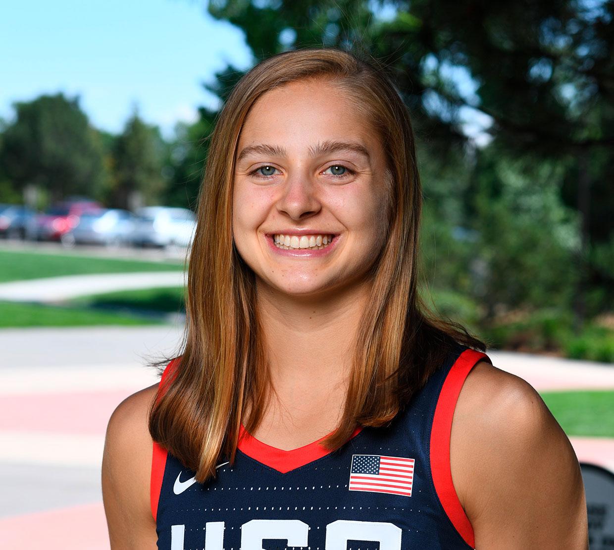 Mikayla Pivec standing in outdoor plaza, wearing a USA basketball jersey