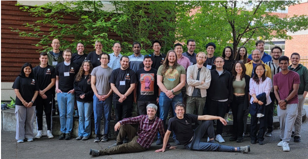 Group of people posing in front of trees.