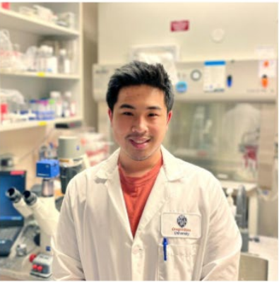 Student in lab coat smiling at camera.