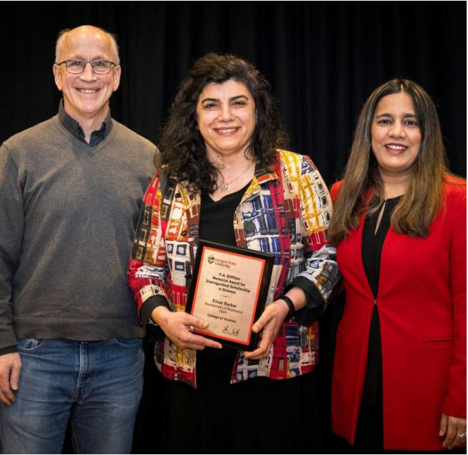 Woman smiling with award.