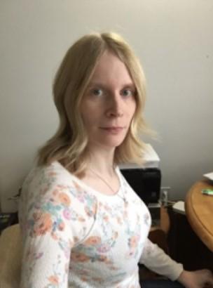 Woman headshot in front of desk.