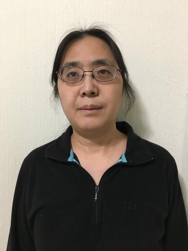 Woman in glasses smiling at camera.