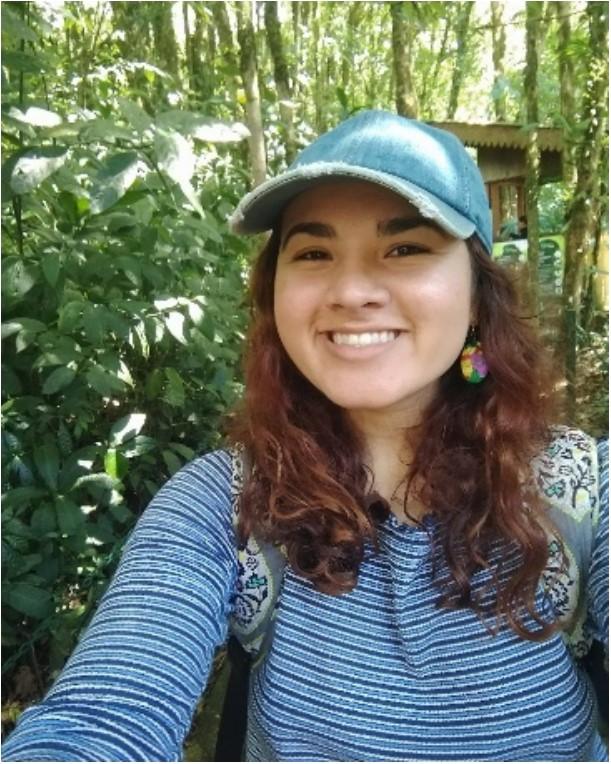 Woman in hat smiling at camera.