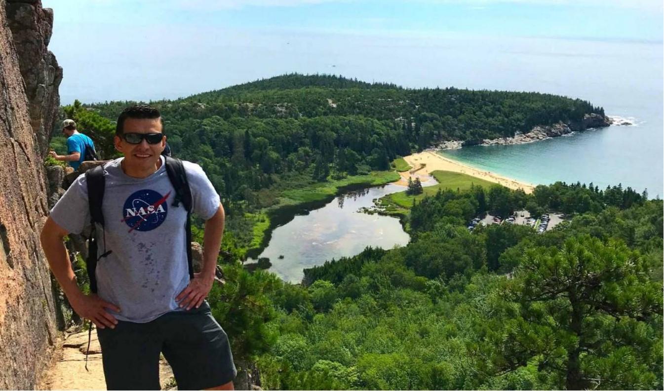 Man hiking at the beach smiling at camera.