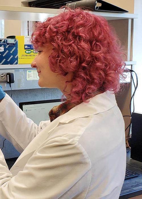 Woman with red hair in lab coat.