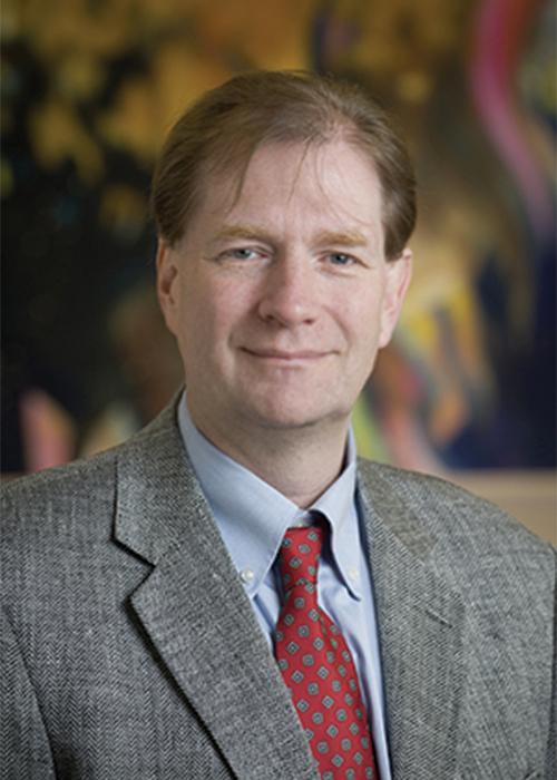 Man in suit and tie smiling at camera.