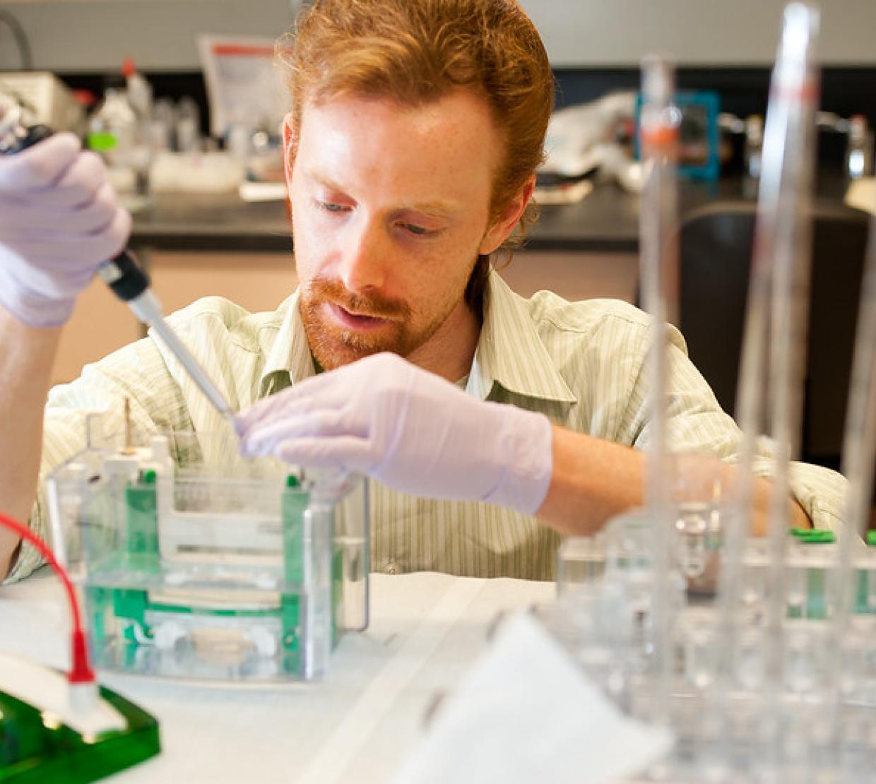Man in lab coat working in lab.