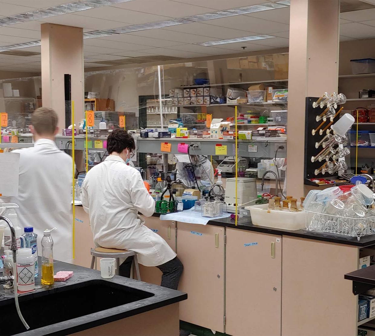 Students in lab coats and masks.