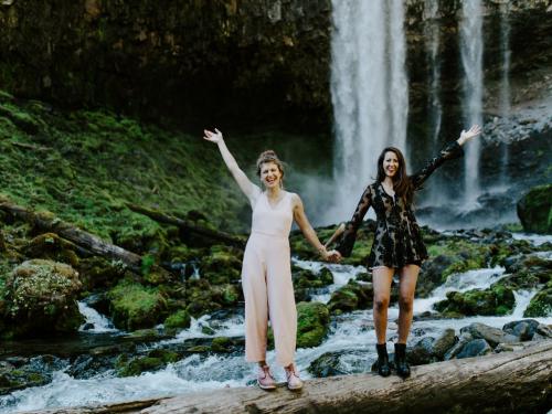 Heather Masson-Forsythe holding hands with her wife, Margaux, at a waterfall.