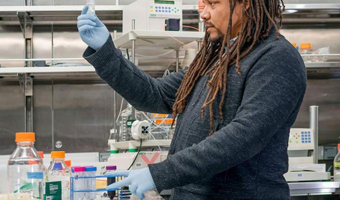 Bil Clemons analyzing test tubes in lab