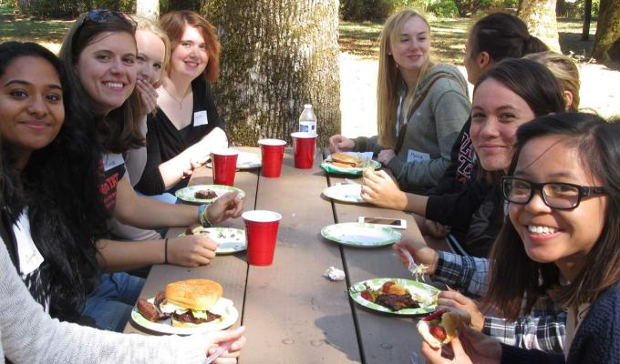students sitting around picnic table eating lunch