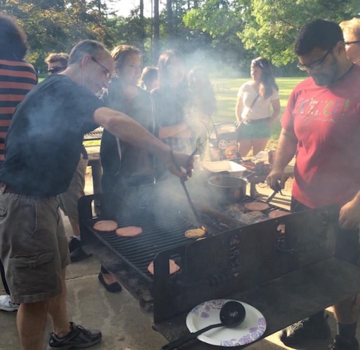 student and Karplus grilling burgers for students