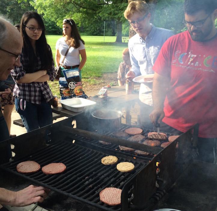 student and Karplus grilling burgers for students