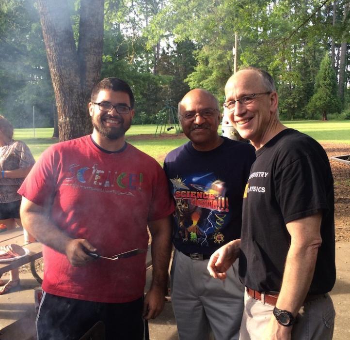 group photo of Karplus, Pantula, and student grilling burgers