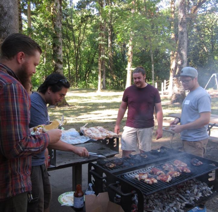 male colleagues grilling chicken