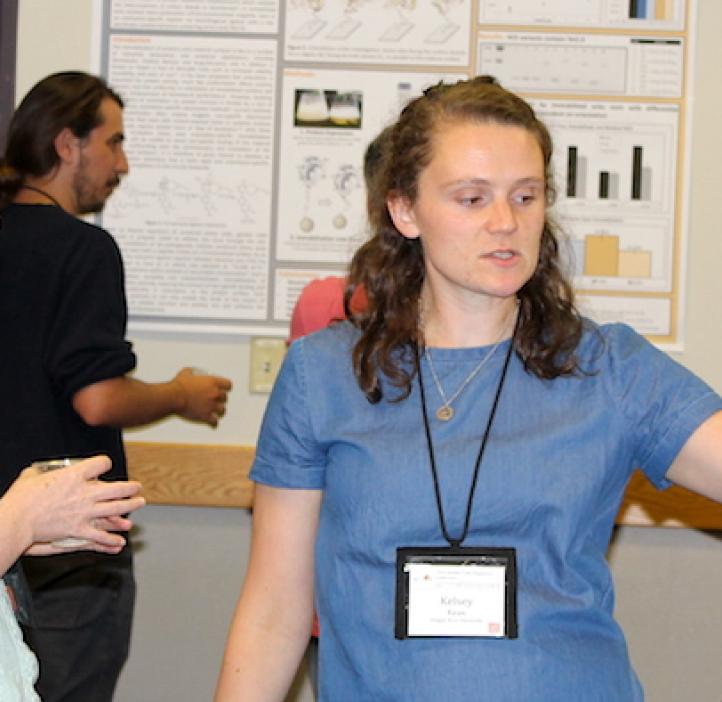 female student presenting poster to female attendee