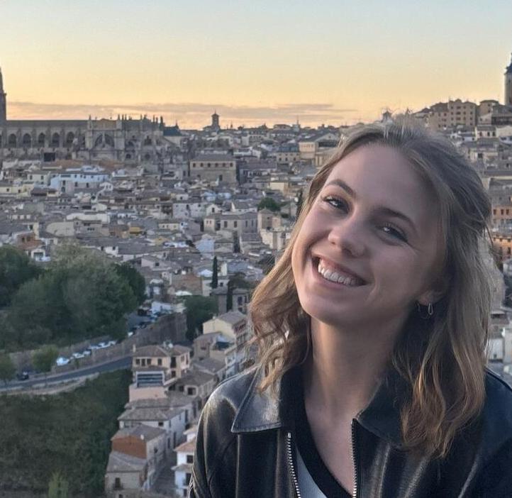 A woman poses for a picture in front of a city in Spain.