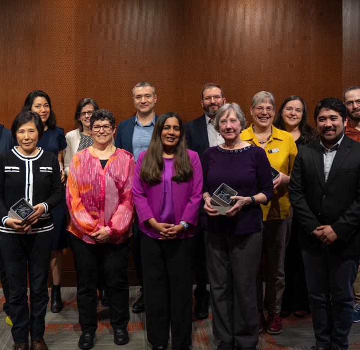 A large group of people holding awards pose for a photo.